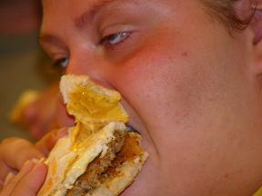 Binge eating on a burger, stuffing her face